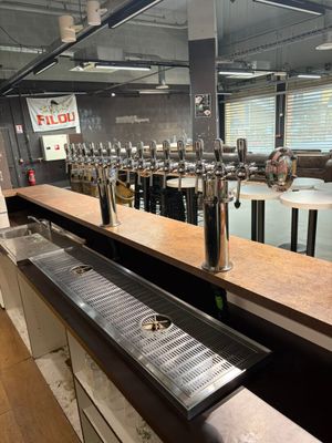 un long comptoir avec toute une série de robinets à bière
