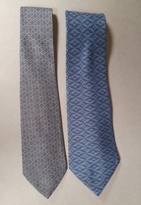 pair of two neck ties on a table with a white background