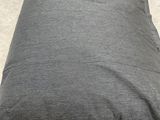 grey pillow on the floor in a room with a wooden pallet in the background