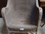 a wicker chair that is sitting on a tile floor