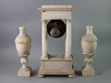 three vases and a clock sitting on a table