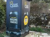 a trash can sitting on the side of the road