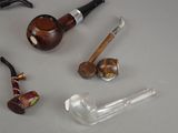 a lot of different types of smoking pipes on the table