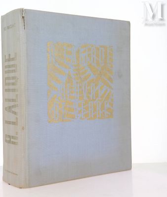 un vieux livre posé sur une table blanche à côté d'un mur blanc