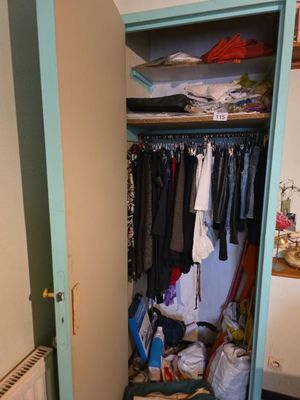 une armoire pleine de vêtements et un radiateur dans un coin de la pièce