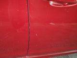 a close up of a red car door with the door handle missing
