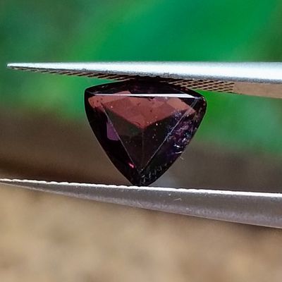 une pierre de grenat de forme triangulaire montée sur un fil