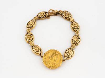 Gros plan sur un bracelet en or orné d'une pièce de monnaie