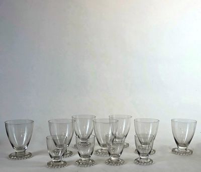 plusieurs verres à vin vides sont alignés sur une surface blanche
