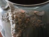 a large vase with a head of a goat on it
