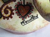 a vase with a heart on it sitting on a table