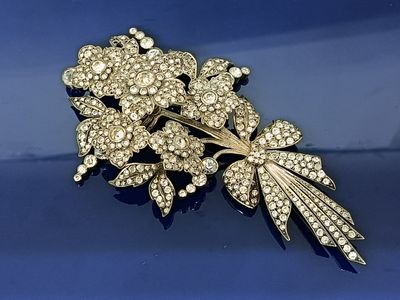 une image représentant une broche en or ornée de fleurs et de feuilles