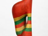 wooden sculpture of a woman ' s foot with a red, green, and yellow stripe on it