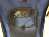 a blue chair with a seat that has a bag in it