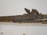 a very old gun that is on display in a museum