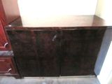 a brown cabinet with a mirror on top of it