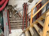 un escalier dans un garage, avec un tuyau rouge à côté