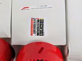 three red circular holes in a box on a white surface
