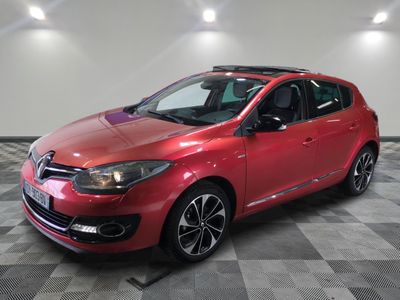 une voiture rouge est garée dans une pièce au sol en damier