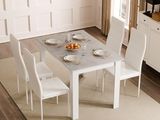 une table et des chaises blanches dans une pièce où est accrochée une horloge au mur
