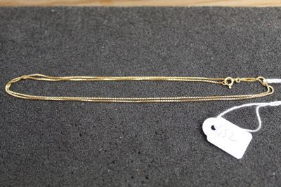 a gold chain with a white tag on it