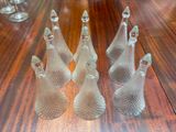 three clear glass christmas trees sitting on top of a wooden table