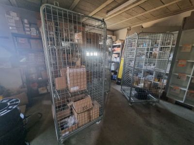 de nombreuses cages surmontées de cartons dans un entrepôt