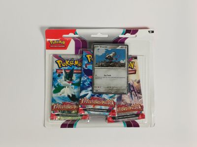 un gros plan sur un paquet de cartes à collectionner Pokémon posé sur une surface blanche
