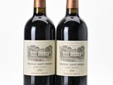 two bottles of red wine sitting next to each other on a white surface