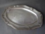 a silver plate on a table with a black background