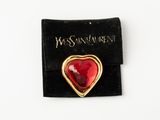 an image of a red heart shaped broochle on a black velvet pouch