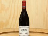a bottle of wine sitting on top of a barrel