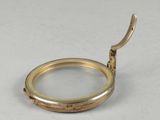 a gold ring with a handle on a white surface