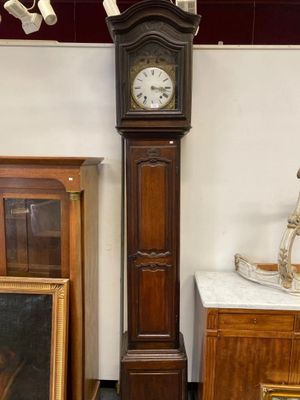 une horloge de parquet dans un coin de la pièce, à côté d'un tableau