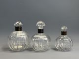 three clear glass perfume bottles with wooden tops