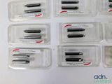 several different types of screws in plastic containers on a white surface