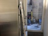 a stainless steel refrigerator in the corner of a kitchen