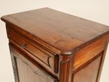a small wooden cabinet with a door on top of it