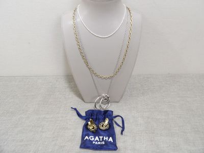 un mannequin blanc portant un collier et un sac bleu