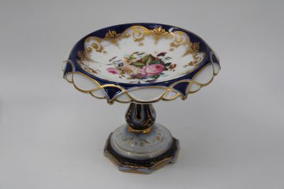 une petite assiette bleue et dorée ornée d'une fleur