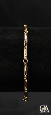gros plan d'un bracelet en or sur fond noir