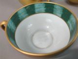 a close up of a green and white cup and saucer on a table