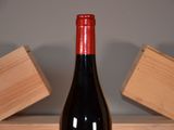 a bottle of wine sitting on a table next to a block of wood