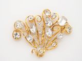 a close up of a gold brooch with clear stones