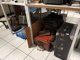 de nombreuses valises et cartons posés par terre dans une pièce