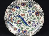 a close up of a plate with flowers and leaves on it