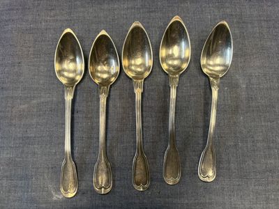 six cuillères sont alignées sur une table