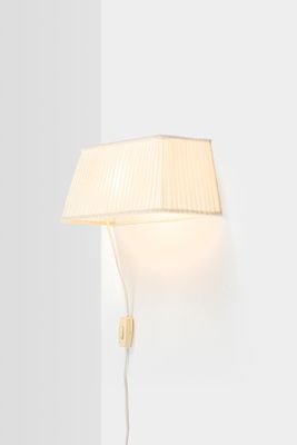 a white lamp on a white wall next to a white wall
