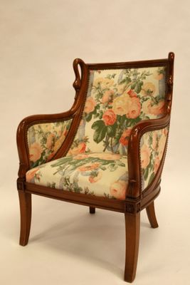 une chaise dont le dossier est recouvert d'un tissu à motifs floraux et dont la structure est en bois
