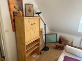 an image of a bedroom with a bed and bookshelf